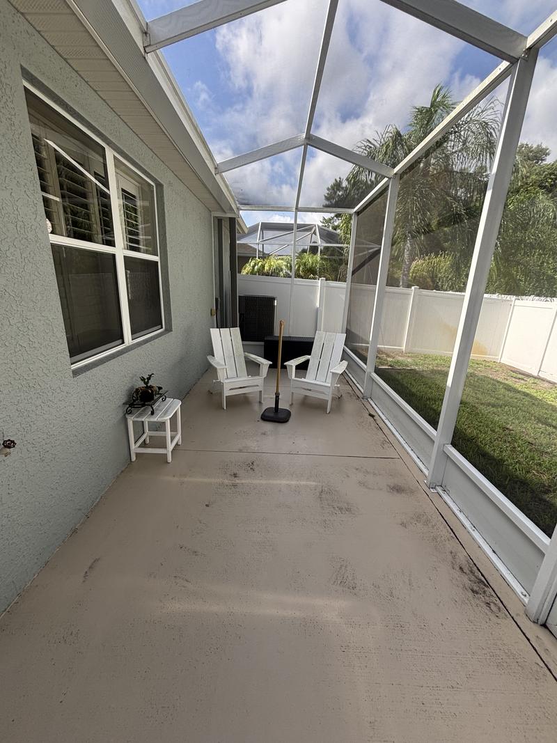 Screened lanai floor stained grey with mildew before cleaning