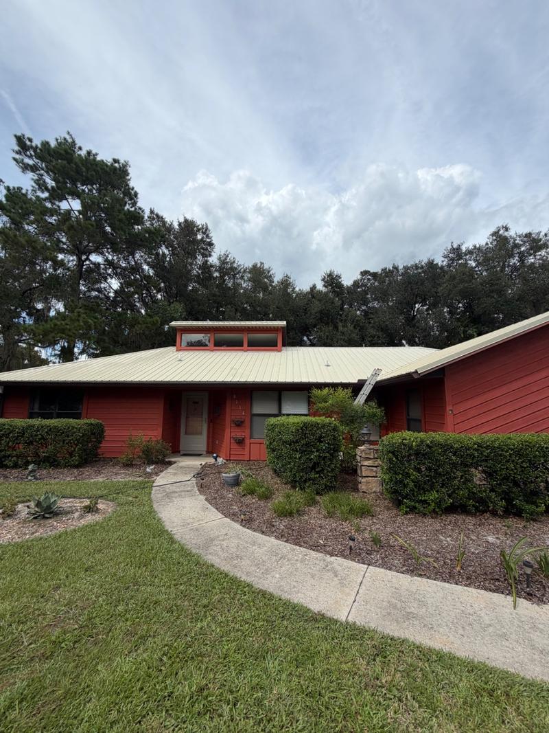 The same house from the front walk, the metal roof clean and light