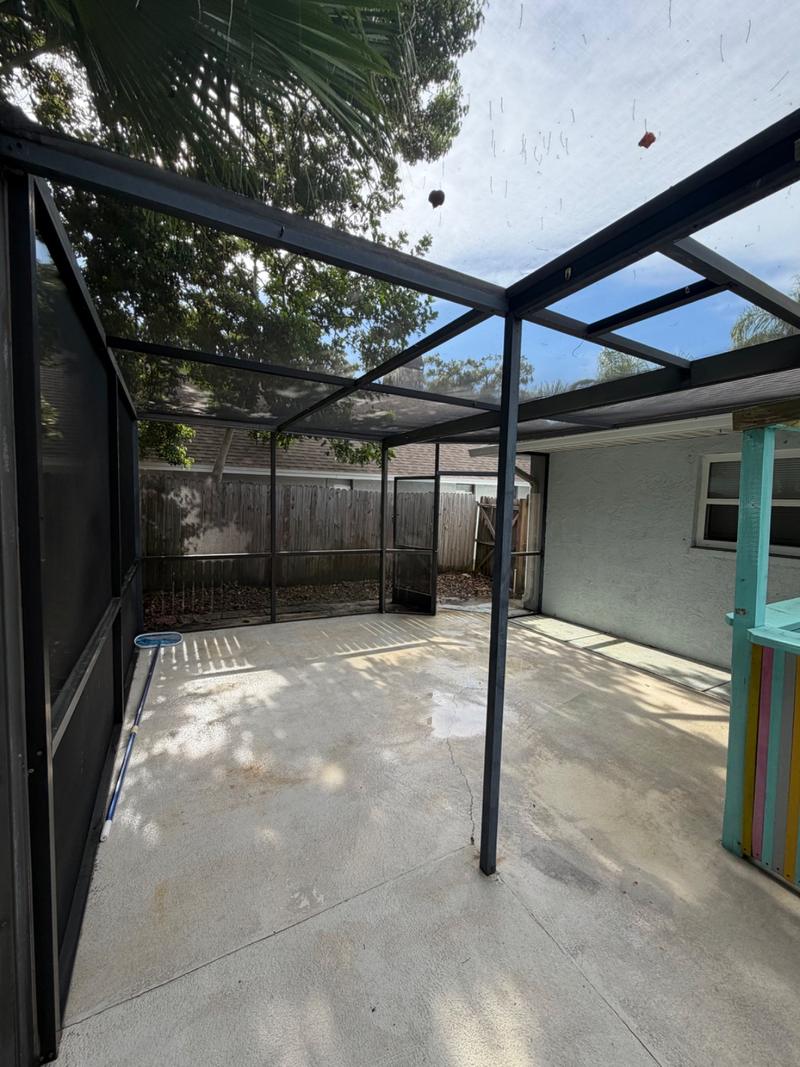 The same pool cage and deck after cleaning, frame and concrete bright