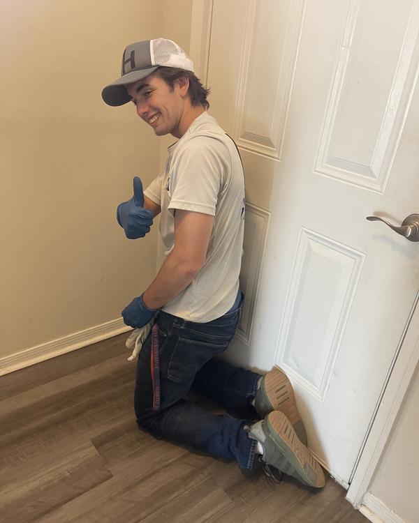 Mason Houghton kneeling in gloves finishing the detail work at the end of a job